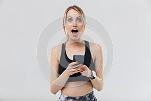 Image of young blond woman 20s dressed in sportswear using smartphone during workout in gym