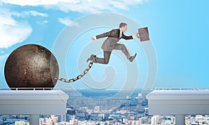 Image of young businessman jumping over gap