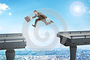 Image of young businessman jumping over gap