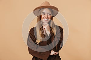 Image of young caucasian girl wearing hat laughing and touching her chin