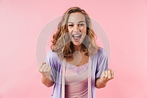 Image of young delighted woman screaming and making winner gesture