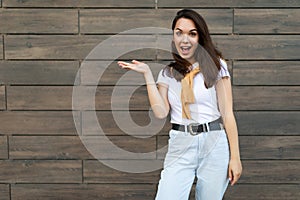 Image of young emotional happy positive beautiful brunette woman wearing casual clothes standing in the street near the