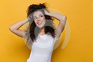 Image of young european woman 20s with curly hair smiling and gr