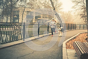 Image of young girl running with her dog, alaskan malamute