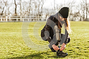 Image of young handicapped sportswoman in tracksuit, squatting a