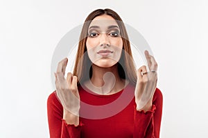 Image of young happy woman holding fingers crossed for good luck. Human emotions, facial expression concept
