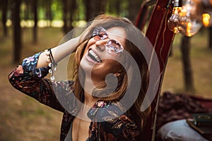 Image of young hippy woman, wearing stylish accessories smiling