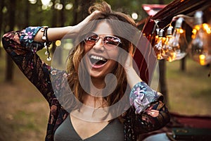 Image of young hippy woman, wearing stylish accessories smiling