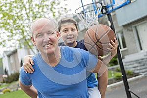 Image of young man and his son playing basketball