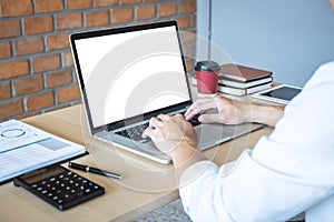 Image of Young man working in front of the laptop looking at screen with a clean white screen and blank space for text and hand