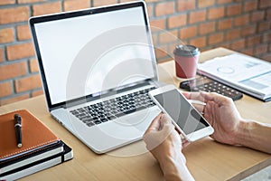 Image of Young man working in front of the laptop looking at screen with a clean white screen and blank space for text, hand