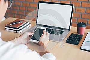 Image of Young man working in front of the laptop looking at screen with a clean white screen and blank space for text, hand