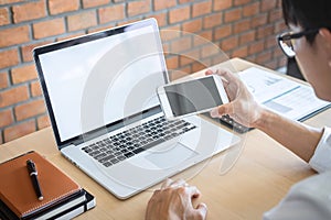 Image of Young man working in front of the laptop looking at screen with a clean white screen and blank space for text and hand