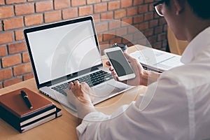 Image of Young man working in front of the laptop looking at screen with a clean white screen and blank space for text, hand