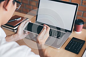 Image of Young man working in front of the laptop looking at screen with a clean white screen and blank space for text and hand