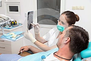 Image of young patient and dentist showing him x-ray radiography