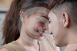 Image of young pleased Asian couple with closed eyes and teardrop touching each other face to face. tenderness and closeness