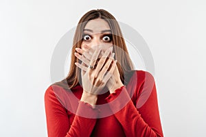 Image of young scared woman covering her mouth with hands. Fright, phobia and facial expression concept