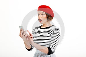 Young shocked woman chatting by mobile phone