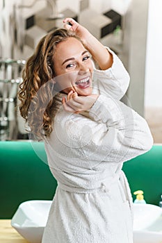 Image of young woman in housecoat standing in bathroom after shower photo