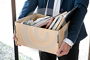 Images of businessman carrying packing up all his personal belongings and files into a brown cardboard box has frustrated and