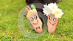 Images of lovely groom and bride just married painted in bright colors on feet of child outdoor. Thinking outside the