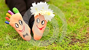 Images of lovely groom and bride just married painted in bright colors on feet of child outdoor. Thinking outside the