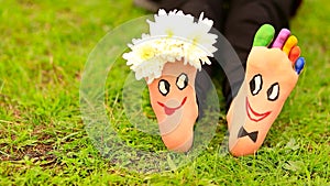 Images of lovely groom and bride just married painted in bright colors on feet of child outdoor. Thinking outside the