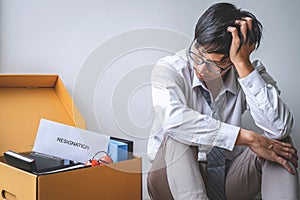 Images of packing up all his personal belongings and files into a brown cardboard box, Businessman has frustrated and stressed to