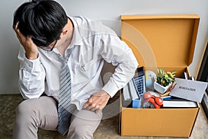 Images of packing up all his personal belongings and files into a brown cardboard box, Businessman has frustrated and stressed to