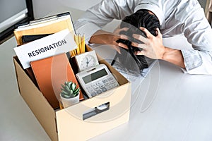 Images of packing up all his personal belongings and files into a brown cardboard box, Businessman has frustrated and stressed to