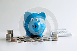 Images of stacking coins pile and blue smiling piggy bank to growing and savings with money box, Saving money for future plan and