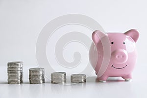 Images of stacking coins pile and pink smiling piggy bank to growing and savings with money box, Saving money for future plan and