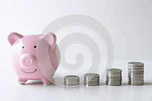 Images of stacking coins pile and pink smiling piggy bank to growing and savings with money box, Saving money for future plan and