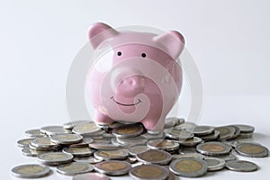 Images of stacking coins pile and pink smiling piggy bank to growing and savings with money box, Saving money for future plan and