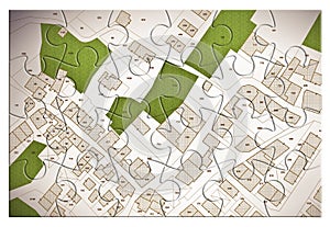 Imaginary cadastral map of territory with a free green land available for building construction. Concept with buildings in jigsaw