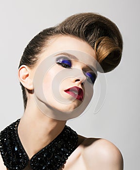 Imagination. Bright Young Woman with Blue Holiday Eye Makeup and Festive Hairstyle