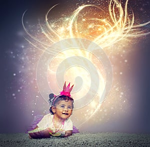 Imagination brings stories to life. an adorable little girl sitting on the floor and reading a glowing book.