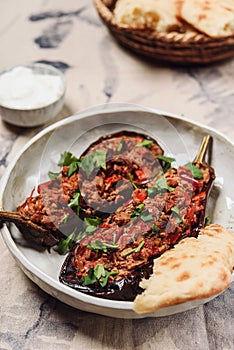 Imam bayildi. Traditional delicious Turkish food: halves of baked eggplant stuffed with vegetables