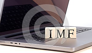 IMF word on wooden block on laptop , business concept