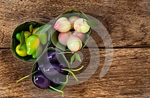 Imitation Fruits (Kanom Look Choup) Thai dessert on wood floor