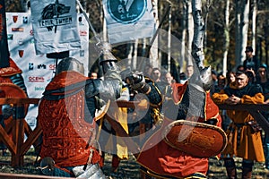 Two knights in the arena fight with swords.