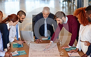 Immersed in their latest project. a group of businesspeople discussing documents in a meeting.