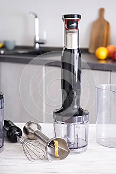 Immersion hand blender on table on a kitchen background, vertically