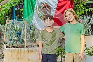 Immigrant boys in Mexico in front of the Mexican flag. New Mexicans