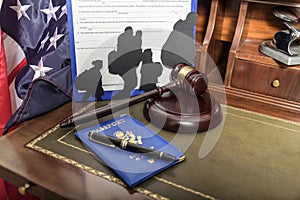 Immigration law concept. Gavel, passport and Silhouette of immigrants on wooden table.