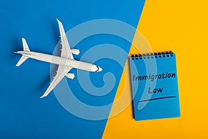 Immigration law. MEssage in notepad near airplane model. Immigration and emigration, refugee issues and citizenship