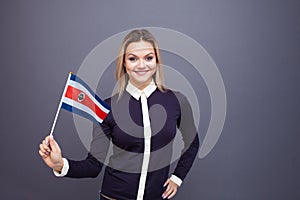 Immigration and the study of foreign languages, concept. A young smiling woman with a costa rica flag in her hand. photo