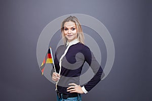 Immigration and the study of foreign languages, concept. A young smiling woman with a Germany flag in her hand.