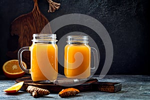 Immune boosting, anti inflammatory smoothie with orange, pineapple, turmeric. Detox morning juice drink photo